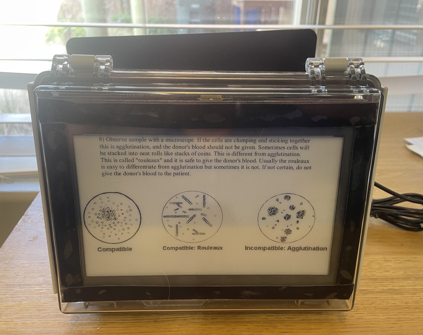 SPRG device: a sealed, latched waterproof case with a sunlight-readable e-ink screen showing reference text