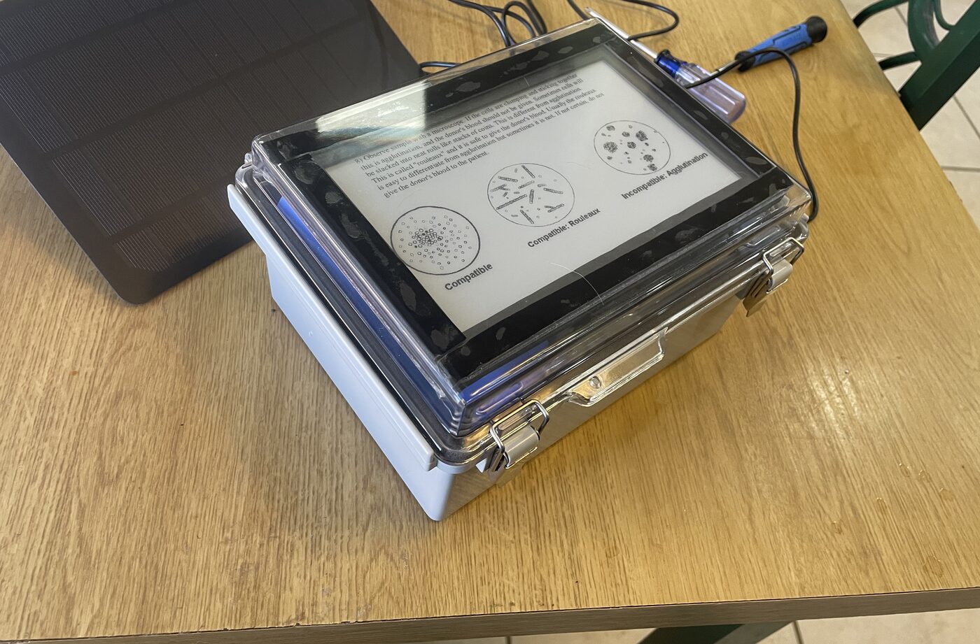 SPRG device next to its 10W solar charging panel on a table